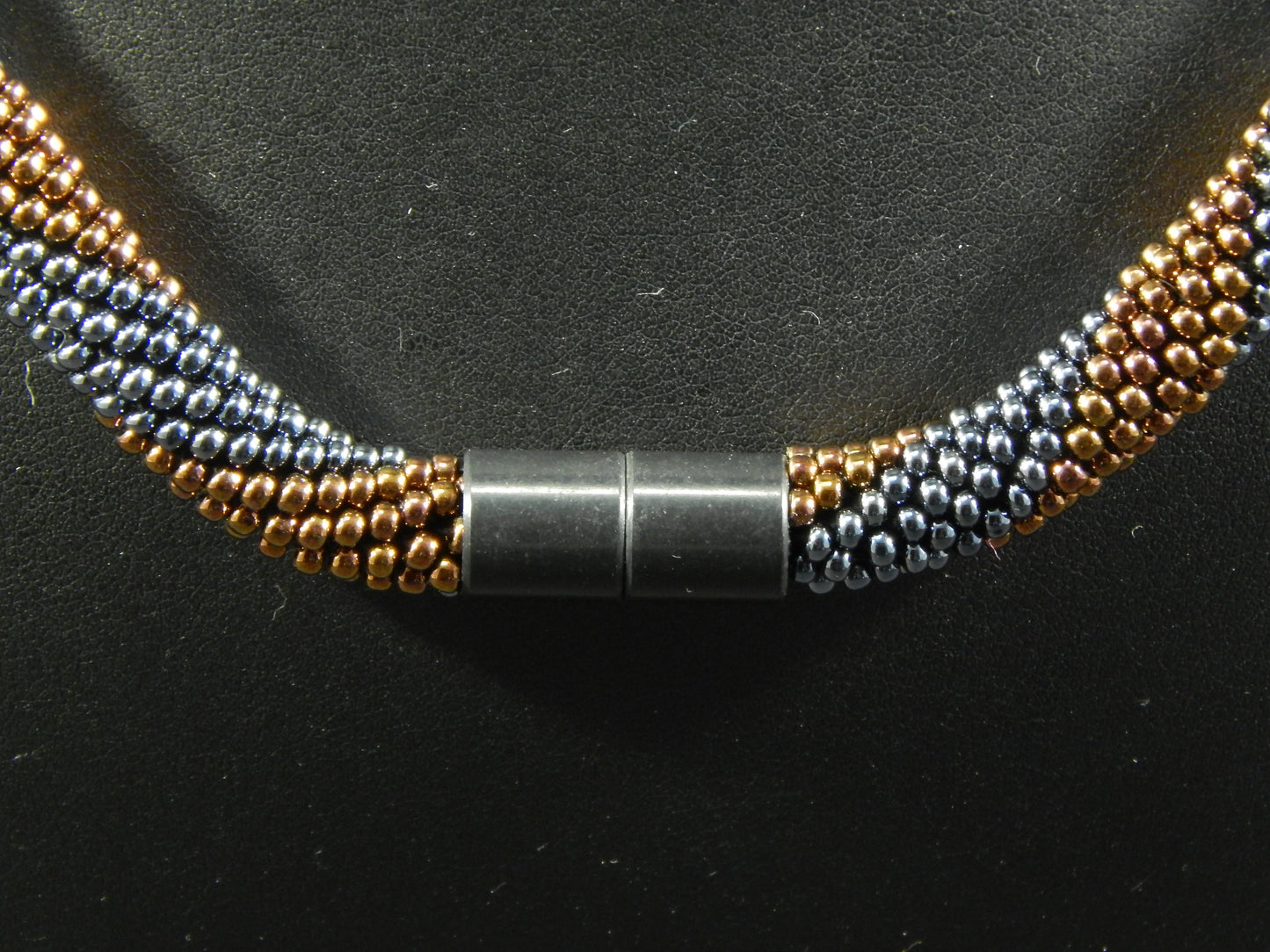 Dunkelgraue- kupferfarbige Kette mit Spiralmuster und glänzenden Kristallelementen