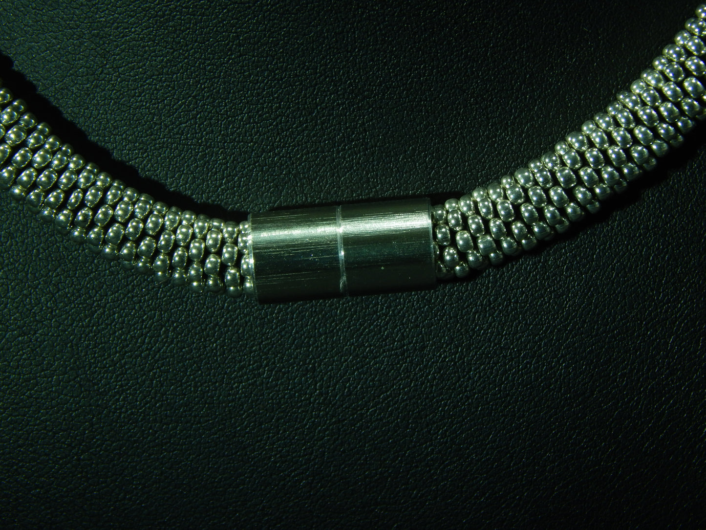 silberfarbene Kette mit schwarz schimmernden Kristallelementen